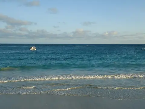 Blått hav med låga vågor som rullar in mot Liidostranden i Mogadishu under en ljus himmel