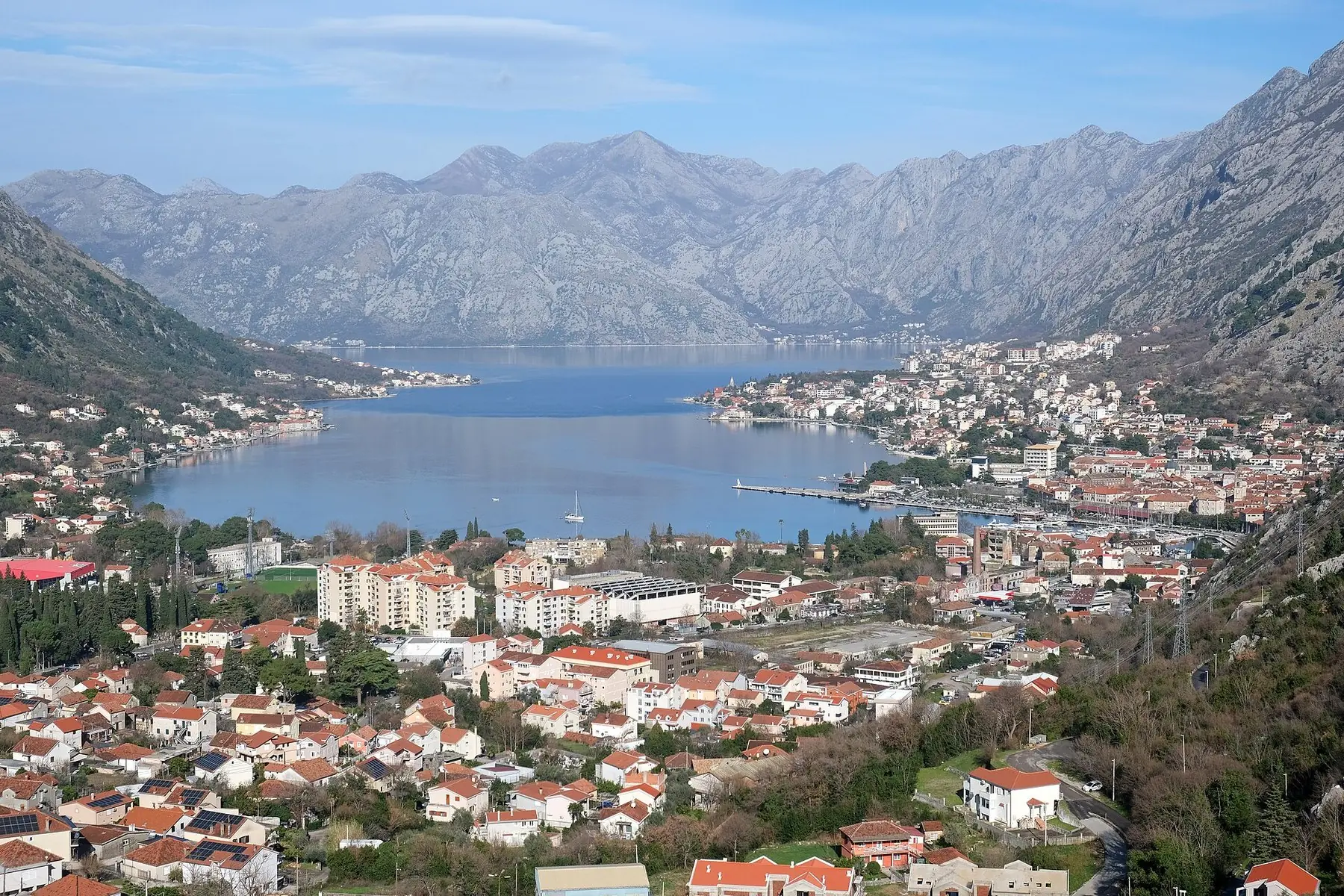 Staden Kotor med röda tak vid en smal vik omgiven av höga berg