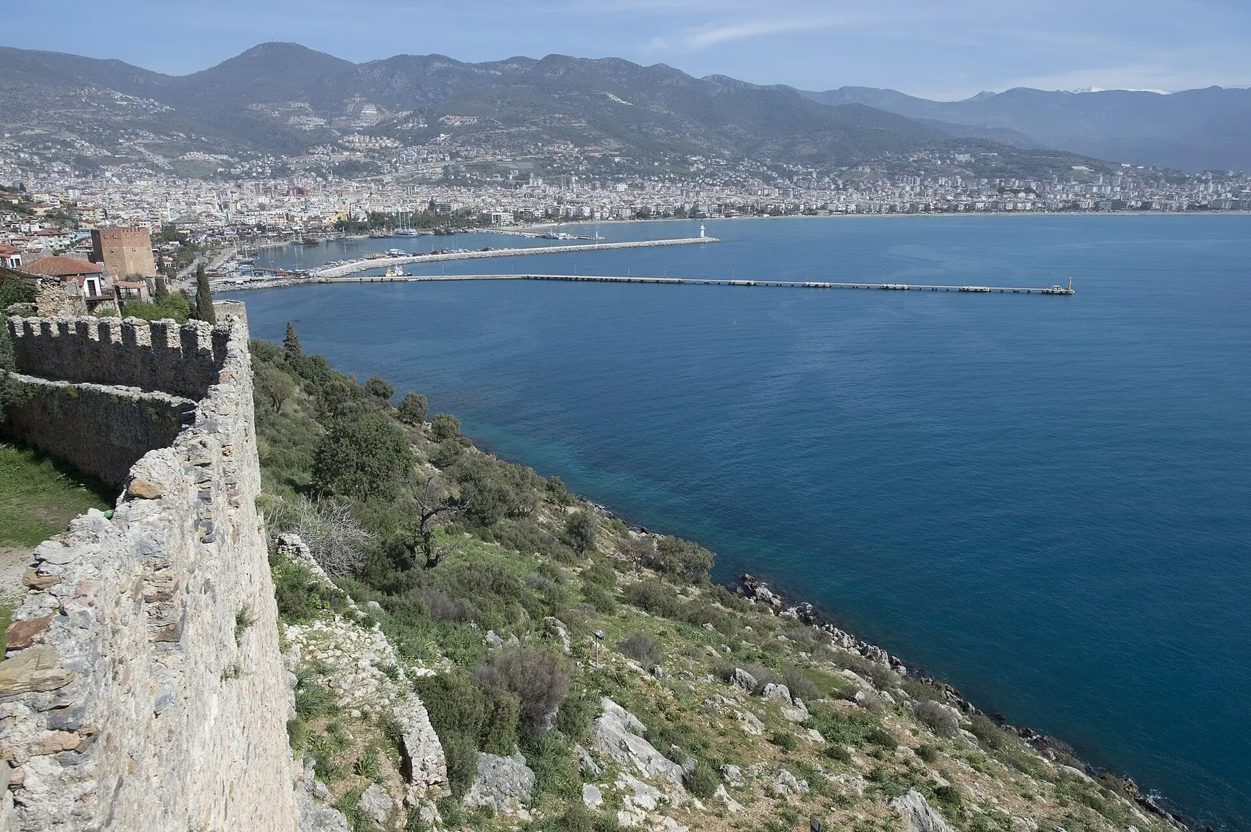 Borgmuren på klippan i Alanya med utsikt över den blå bukten, staden och Taurusbergen