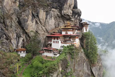 Klostret Taktsang, Tigerboet, klamrar sig fast vid en brant klippvägg ovanför skogsklädda dalar i Bhutan