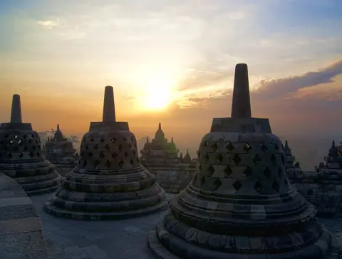 Klockformade stenstupor på templet Borobudur i soluppgångens gyllene ljus på Java