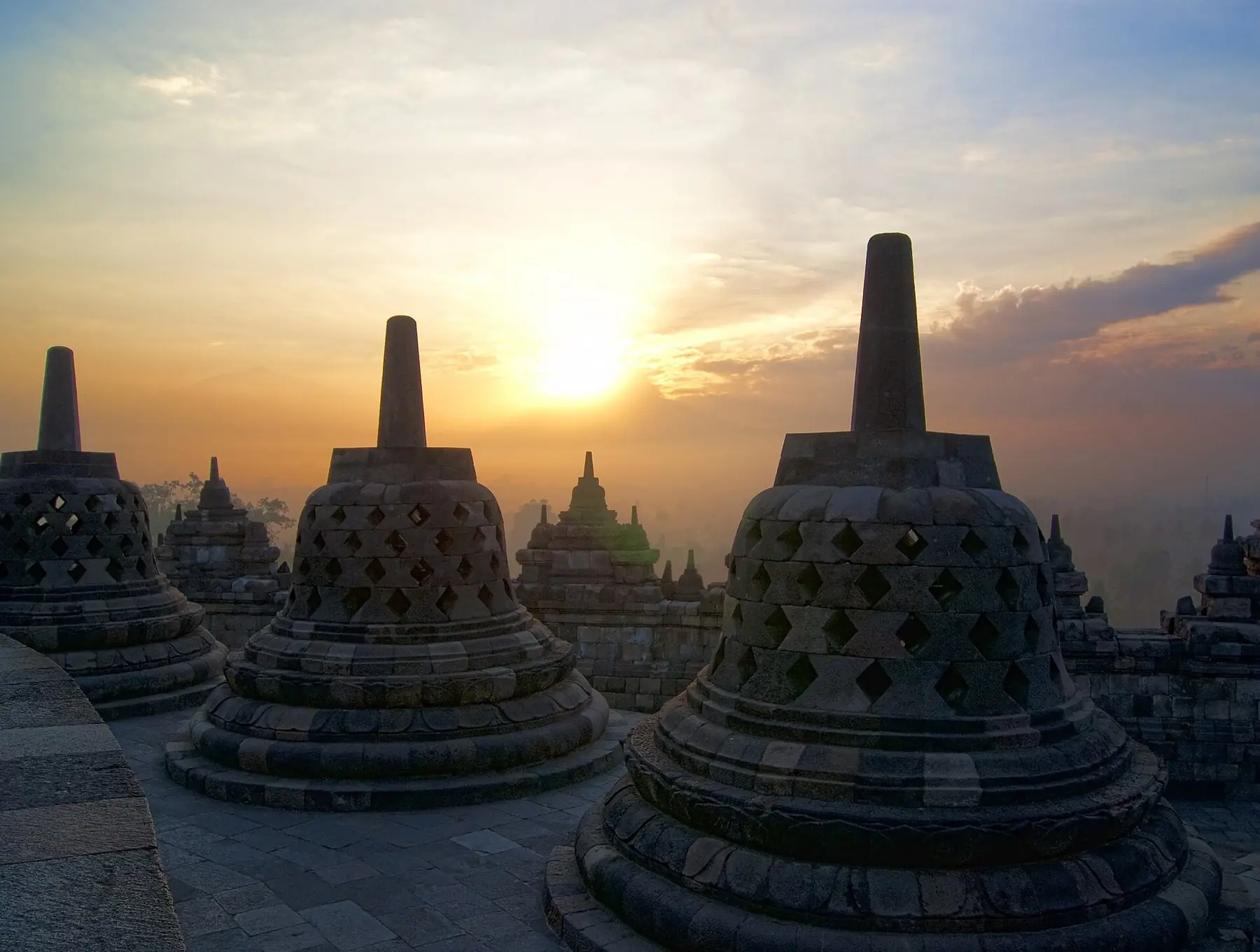 Klockformade stenstupor på templet Borobudur i soluppgångens gyllene ljus på Java