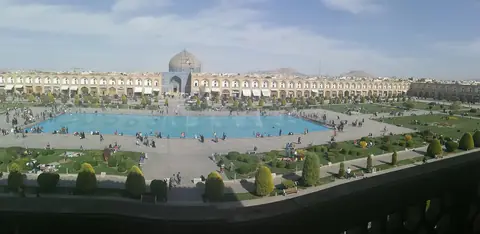 Det stora torget Naqsh-e Jahan i Isfahan med en lång bassäng, trädgårdar och en moské med kupol