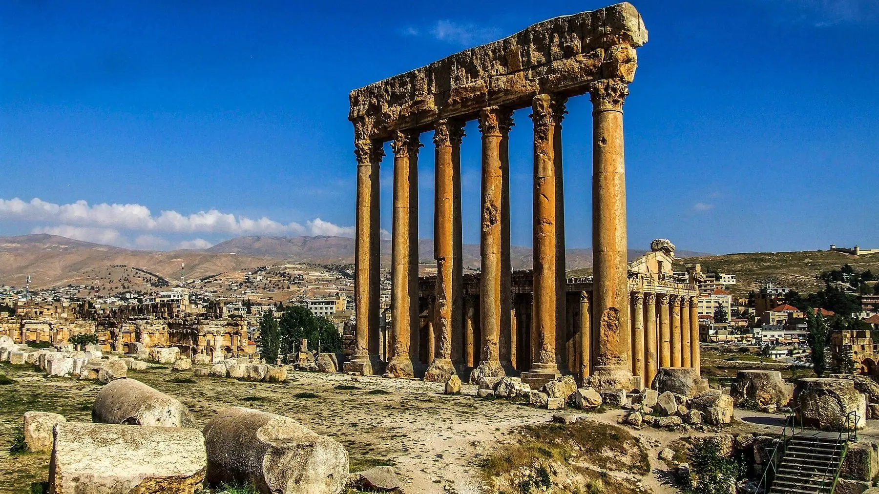 Jupitertemplets sex höga kolonner bland antika ruiner i Baalbek under blå himmel