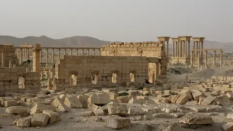 Antika kolonnader och stenmurar i ruinstaden Palmyra i den syriska öknen