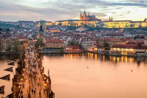Karlsbron och Pragborgen i kvällsljus över floden Moldau i Prag