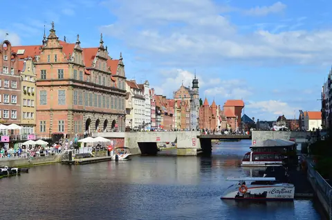 Gröna porten och gamla gavelhus längs floden Motława i Gdańsk en solig dag