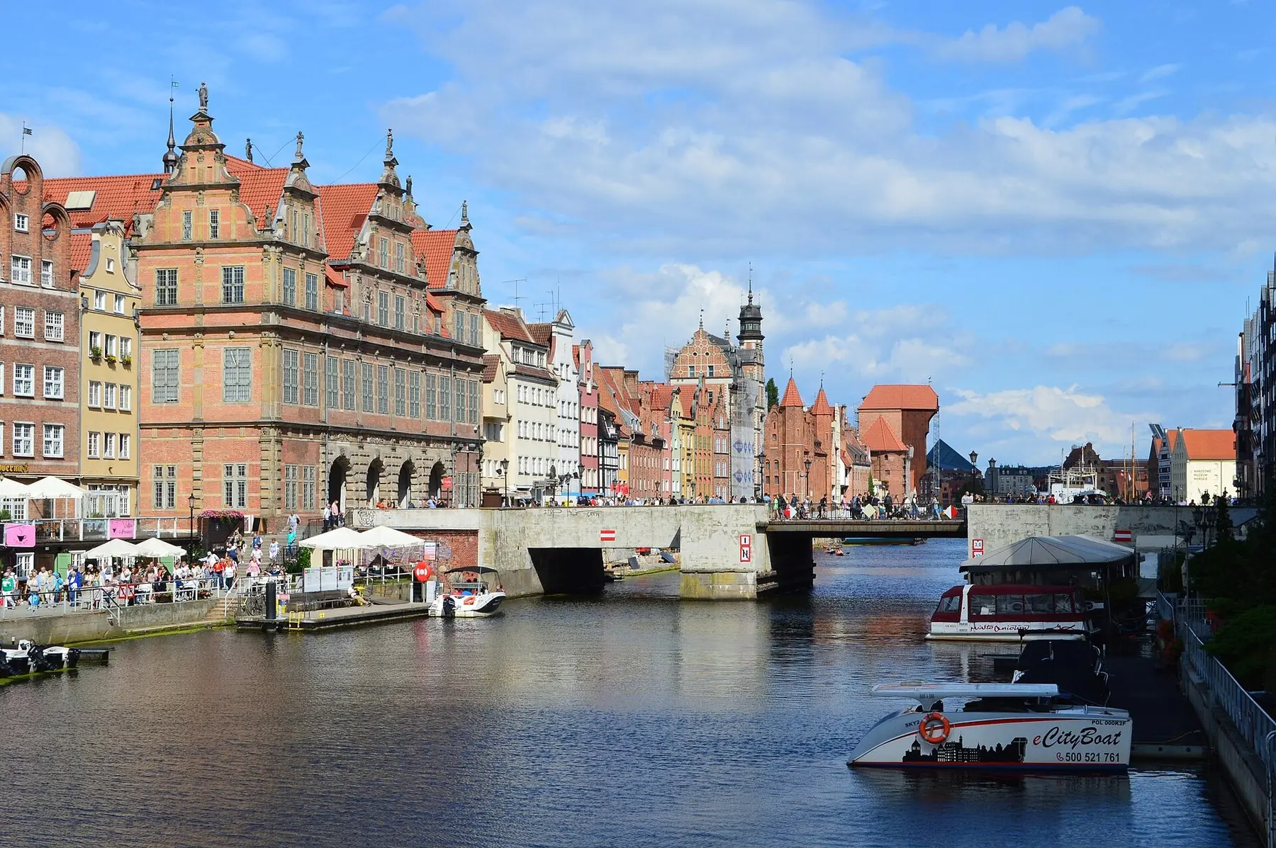 Gröna porten och gamla gavelhus längs floden Motława i Gdańsk en solig dag
