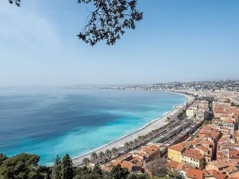 Den turkosa Änglabukten och Promenade des Anglais sedda från slottskullen i Nice