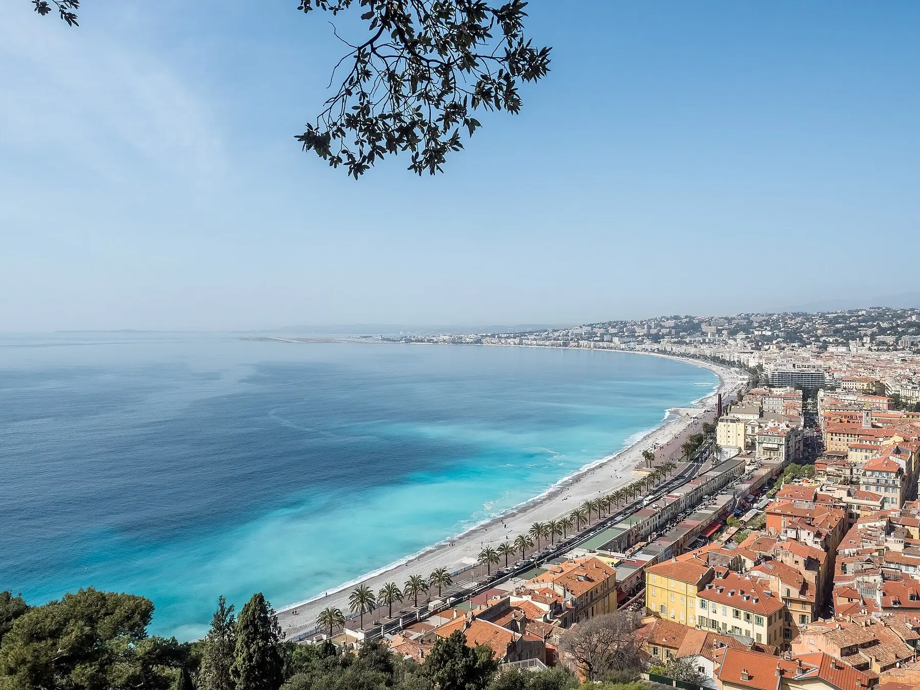 Den turkosa Änglabukten och Promenade des Anglais sedda från slottskullen i Nice