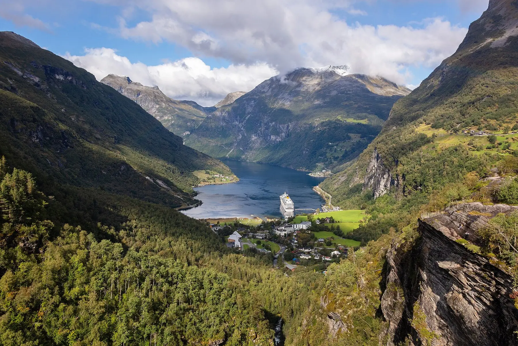 Geirangerfjorden mellan branta gröna fjällsidor sedd från utsiktspunkten Flydalsjuvet