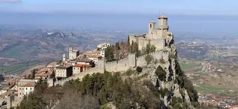 Fästningen Guaita på en brant klippa ovanför gamla stan i San Marino med vidsträckt landskap bakom