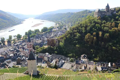 Småstaden Bacharach med skiffertak och kyrktorn vid Rhen, med borgen Stahleck på skogsåsen ovanför