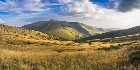 Gyllene bergsängar och gröna åsar under drivande moln i Karpaterna i västra Ukraina