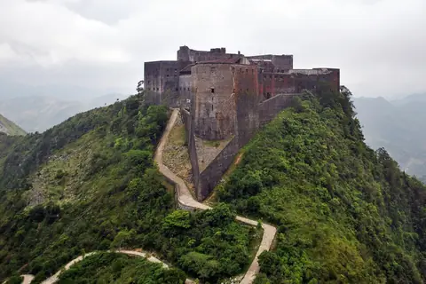 Fästningen Citadelle Laferrière på en grön bergstopp med en slingrande väg