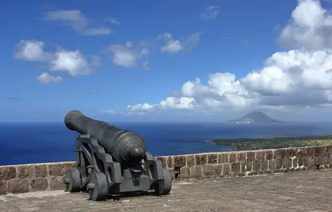 Kanon på fästningen Brimstone Hill med utsikt över det blå havet