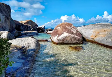 Stora granitblock i klart grunt vatten vid The Baths på Virgin Gorda