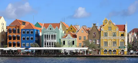 Färgglada kolonialhus längs kajen Handelskade i Willemstad
