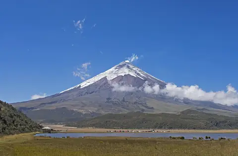 Den snöklädda vulkanen Cotopaxi ovanför högslätten och lagunen Limpiopungo
